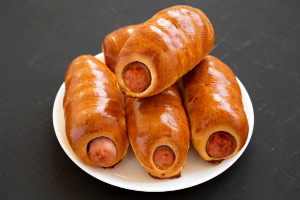 istock Homemade beef sausage kolache on a white plate on a black surface, side view. Close-up. 1174768469