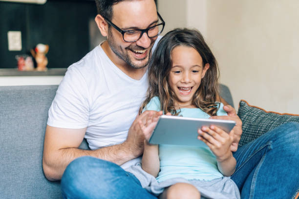 istock Father and daughter looking at digital tablet 1174768555