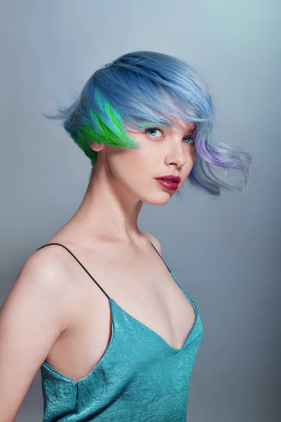 Portrait of a woman with bright colored flying hair, all shades of blue purple. Hair coloring, beautiful lips and makeup. Hair fluttering in the wind. Sexy girl with short hair. Professional coloring retrato de una mujer con el pelo volador de color esbrillante, todos los tonos de azul púrpura. coloración del cabello, hermosos labios y maquillaje. cabello revoloteando en el viento. chica sexy con el pelo corto. coloración profesional