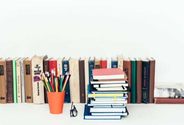Notebooks piles, stack of books education back to school background, textbooks, glasses and pencils in holder with copy space for text