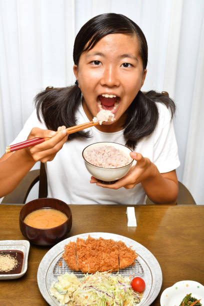 istock Japanese girl enjoys having dinner 1174783774