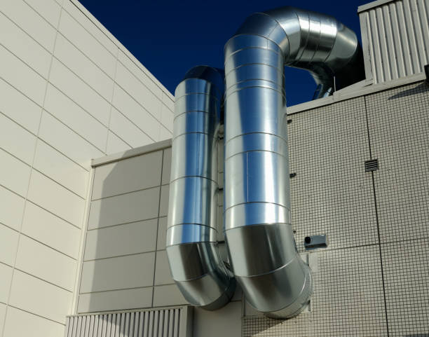 ventilation pipes of industrial building outdoor, against the sky stock photo