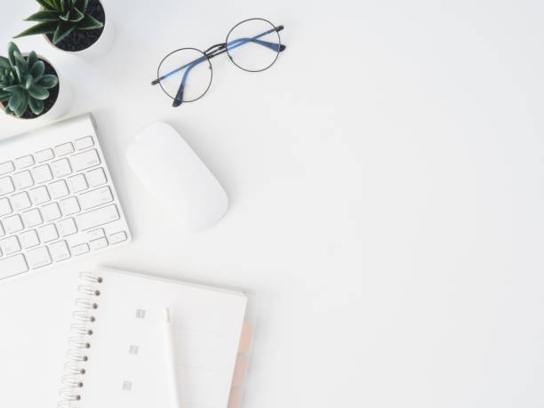 istock top view of office desk table with notebook, plastic plant, digital camera and keyboard on white background, graphic designer, Creative Designer concept. 1174787242