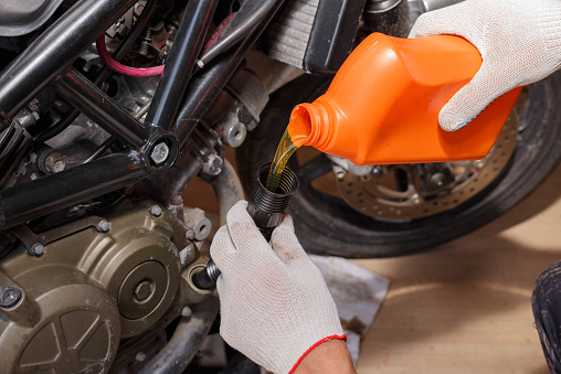 The process of pouring new oil into the motorcycle engine. Motorcycle service.