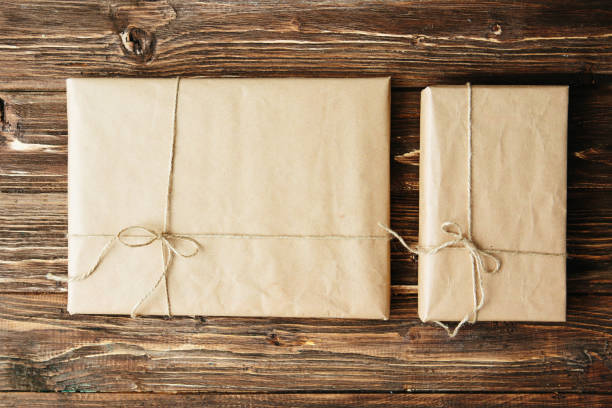 istock Two gift boxes wrapped in kraft paper on wooden table 1174788121