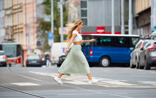 Blonde cool woman crossing street, with phone
