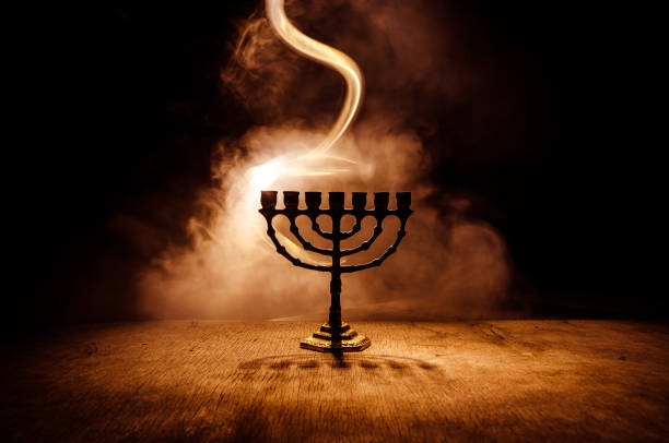 Low key image of jewish holiday Hanukkah background with menorah on dark toned foggy background stock photo