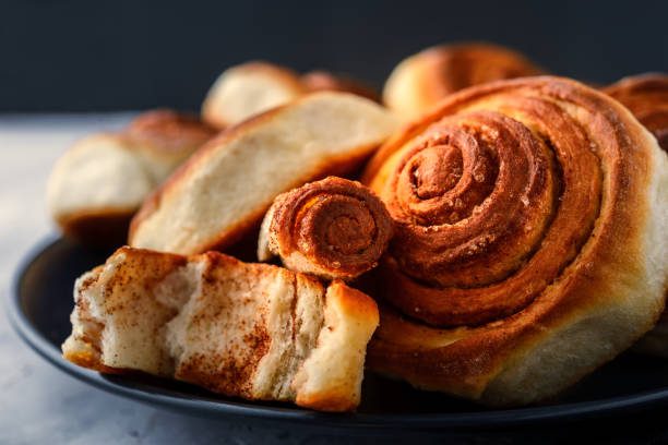 istock Handmade rolls with cinnamon on a dark dish and on a gray background. 1174797646
