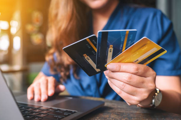 istock a business woman holding credit cards while using laptop computer 1174798033