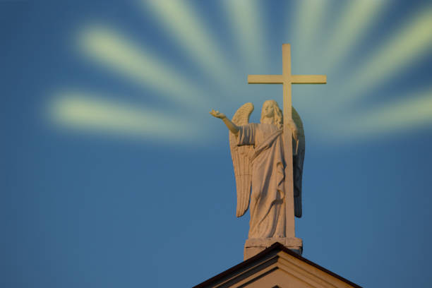 Statue of saint angel with cross and rays