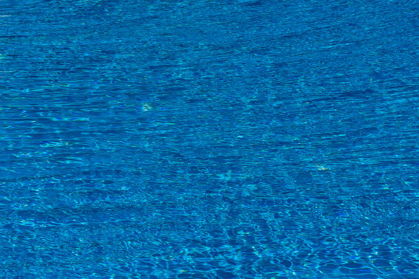 istock Water ripples on blue tiled swimming pool background. Top view 1174800893