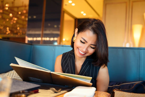 istock Asian Businesswoman ordering dinner in luxury restaurant 1174801819