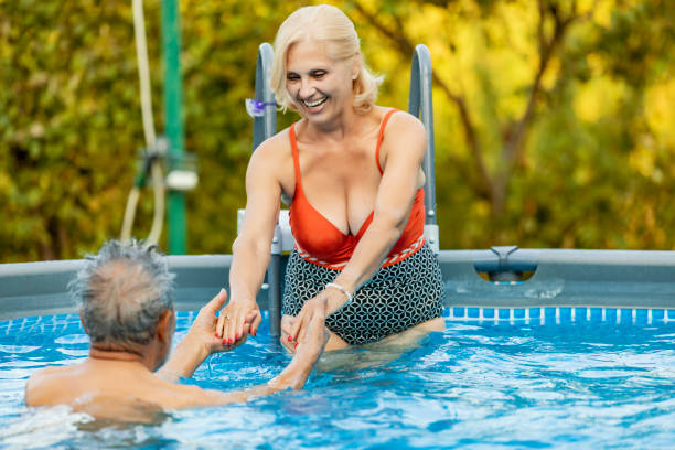 istock Happy Senior couple in the swimming pool 1174802009