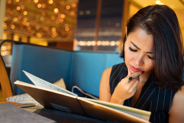 istock Asian Businesswoman ordering dinner in luxury restaurant 1174803063