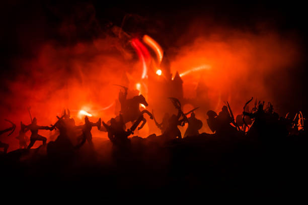 istock Medieval battle scene with cavalry and infantry. Silhouettes of figures as separate objects, fight between warriors on dark toned foggy background with medieval castle. 1174803468