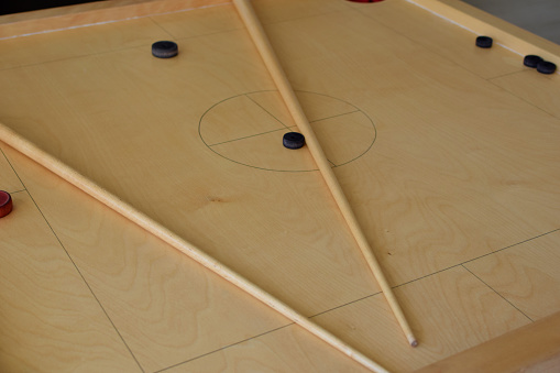 Novuss game board with pool cues