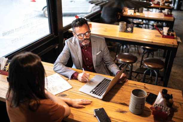istock Businessman interviewing a young woman in a restaurant 1174806261