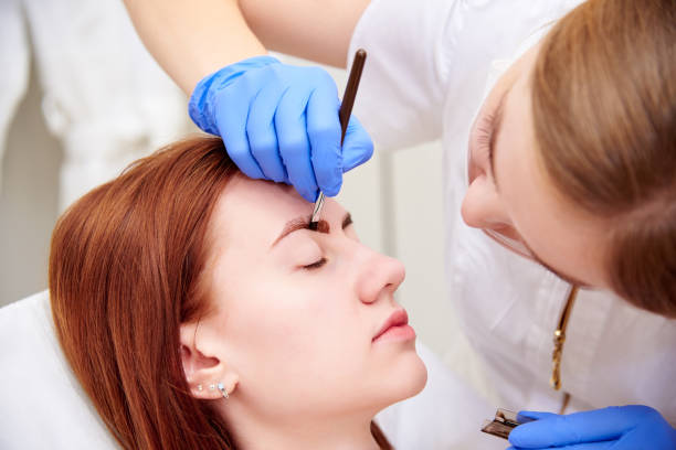 jeune femme sur la correction de sourcil dans la clinique de cosmétologie. - colorant capillaire photos et images de collection