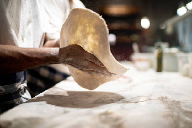 pizzaiolo che prepara l'impasto della pizza al ristorante - pizza one person service human hand foto e immagini stock