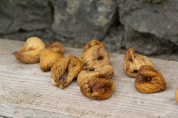 istock Isolated dried figs on wooden background 1174813170