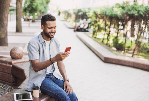 istock Cheerful young man using smart phone in a city 1174815032