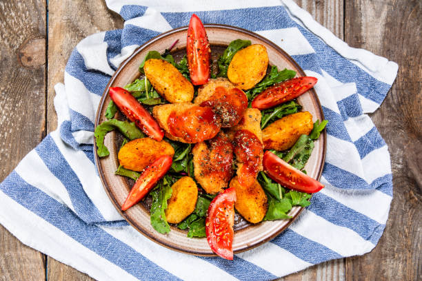 Fried chicken nuggets with baked potatoes and vegetables