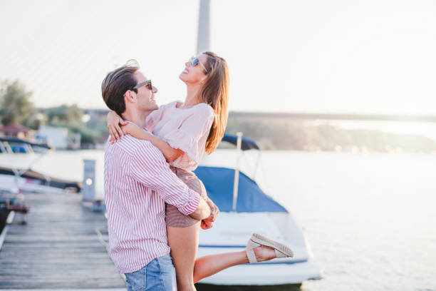 istock Young couple in love on the river dock 1174816481