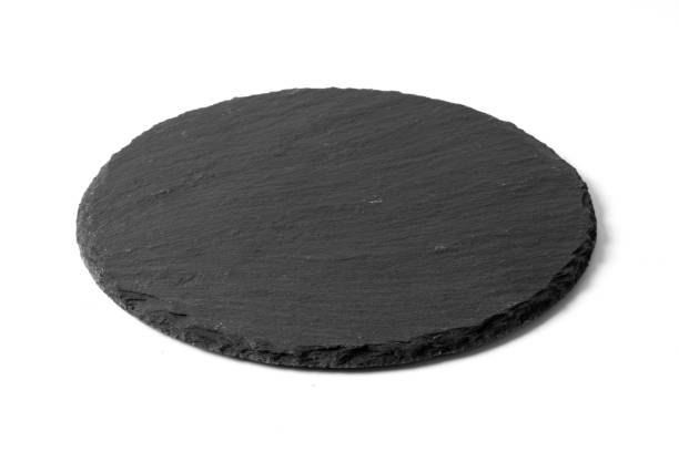 istock Black round stone plate isolated on white background 1174817740