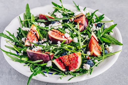 Arugula salad with fresh figs, blueberries and goat cheese, balsamic sauce dressing