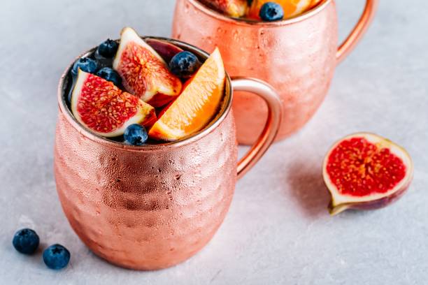 istock Fig Moscow mule ice cold cocktail in copper cup with blueberries and orange 1174818876