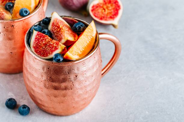 istock Fig Moscow mule ice cold cocktail in copper cup with blueberries and orange 1174818891