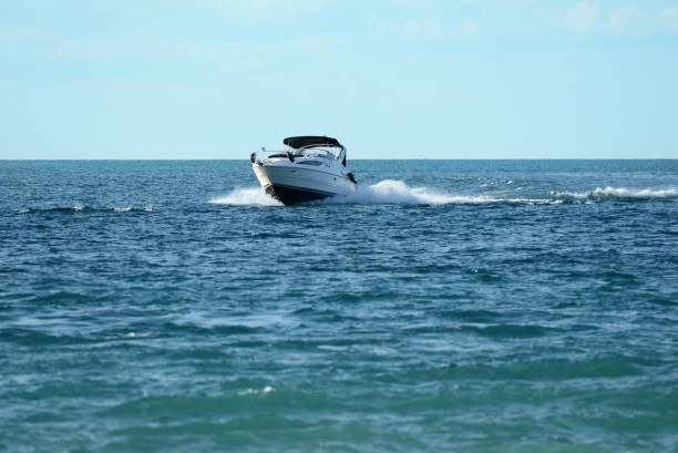 new powerboat speeding towards camera new powerboat speeding towards camera with blue sky racing boat photos stock pictures, royalty-free photos & images