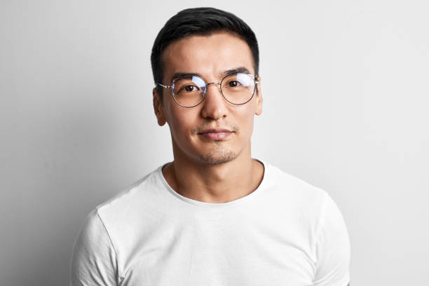 Portrait of a smart young Kazakh man in glasses and a T-shirt on a white background. Asian handsome student creative designer Portrait of a smart young Kazakh man in glasses and a T-shirt on a white background. Asian handsome student creative designer kazakhstan stock pictures, royalty-free photos & images