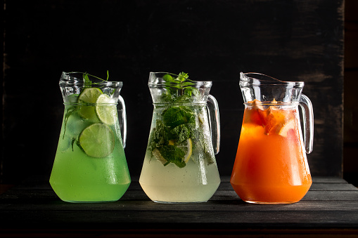 Glass Pitchers With Different Lemonade Mojito Tarragon And Orange On Black  Background Stock Photo - Download Image Now - iStock