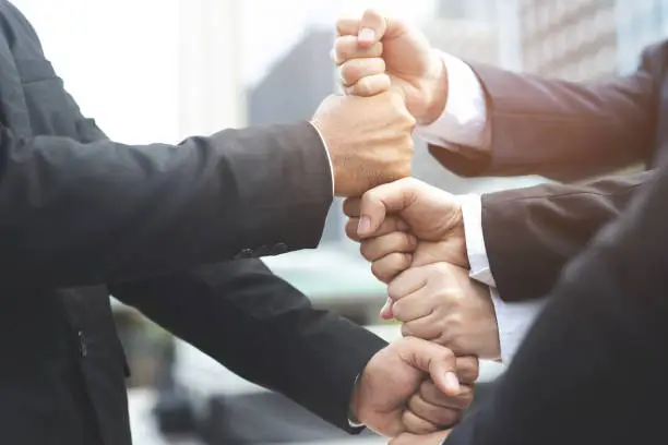 Photo of Close up of Group people of businessmen joining putting their hands together with stack of hands showing unity and teamwork. concept Success and encouragement to overcome obstacles. soft focus.