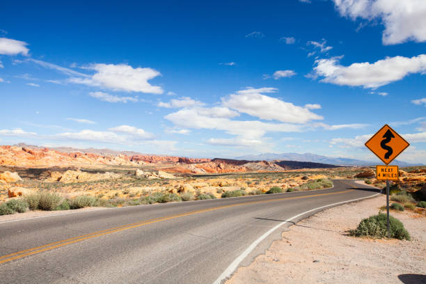 estrada vazia com o sinal de estrada - arid climate asphalt barren blue - fotografias e filmes do acervo