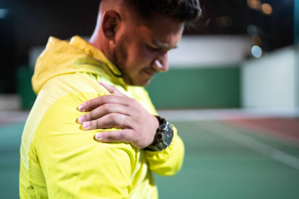 dor do sentimento do homem no ombro - clínica de treino desportivo - fotografias e filmes do acervo