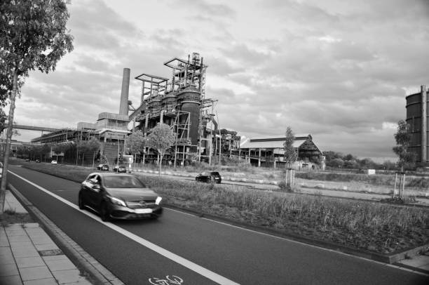 samochody przejeżdżają obok hochofenplatz - zlikwidowanej fabryki stali w phoenix west, dortmund - niemcy. czarno-biały obraz - 7656 zdjęcia i obrazy z banku zdjęć