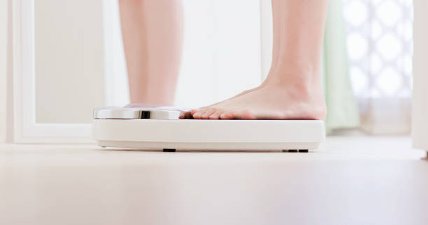 istock Girl measure weight 1174828496