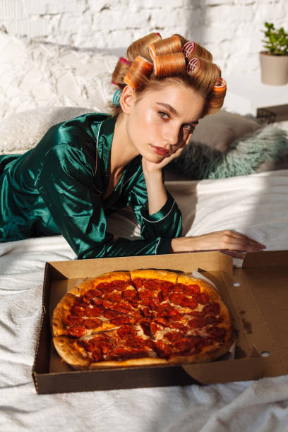 istock young female with pizza box pizza in bed 1174831351