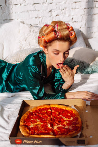 istock young female with pizza box pizza in bed 1174831358