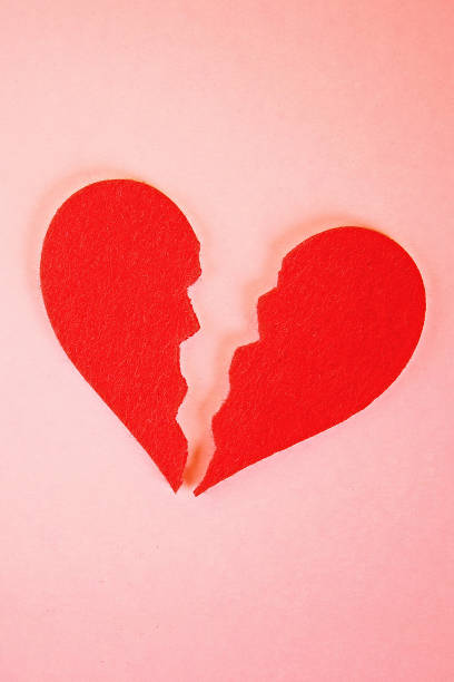 istock Red felt heart broken into two halves on pink background. 1174831539