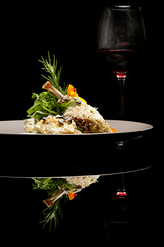 Elegant served crispy duck legs. Exquisite dish. Creative restaurant meal concept. Haute couture food on black. Fine dining concept.