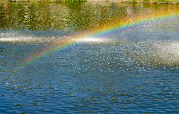 Rainbow spray fountain on the background of the river. Rainbow spray fountain on the background of the river Anapka. old folsom stock pictures, royalty-free photos & images