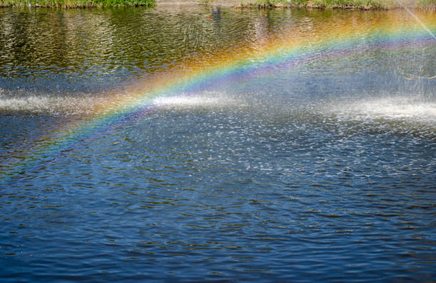 Rainbow spray fountain on the background of the river. Rainbow spray fountain on the background of the river Anapka. old folsom stock pictures, royalty-free photos & images