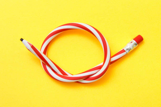 istock Flexible pencil on a yellow background. Bent pencils two-color 1174834169