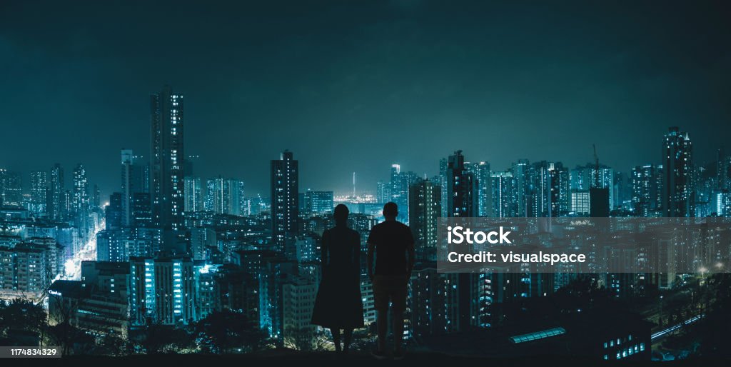 Couple looking at city skyline Conceptual futuristic image of a silhouette couple looking at Hong Kong. Digital Composite. City Stock Photo