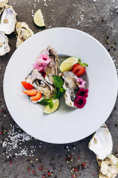 istock Oysters on a dish decorated with flowers on a gray background. Aphrodisiacs. 1174834550