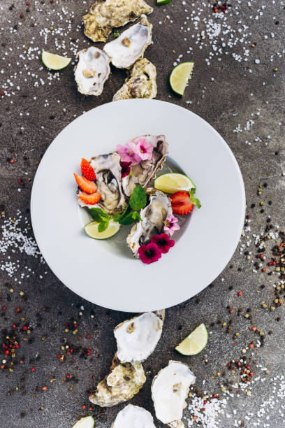 istock Oysters on a dish decorated with flowers on a gray background. Aphrodisiacs. 1174836070
