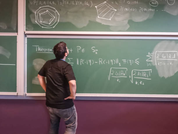 le jeune mathématicien regarde la formule sur le tableau noir - formula blackboard complexity scientist photos et images de collection